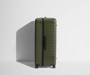 Side product view of The Trunk suitcase in Olive Green to show the slimmer top lid and deeper main compartment for easy access and packing