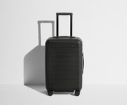 Front product view of The Carry-On suitcase in Jet Black with raised handle