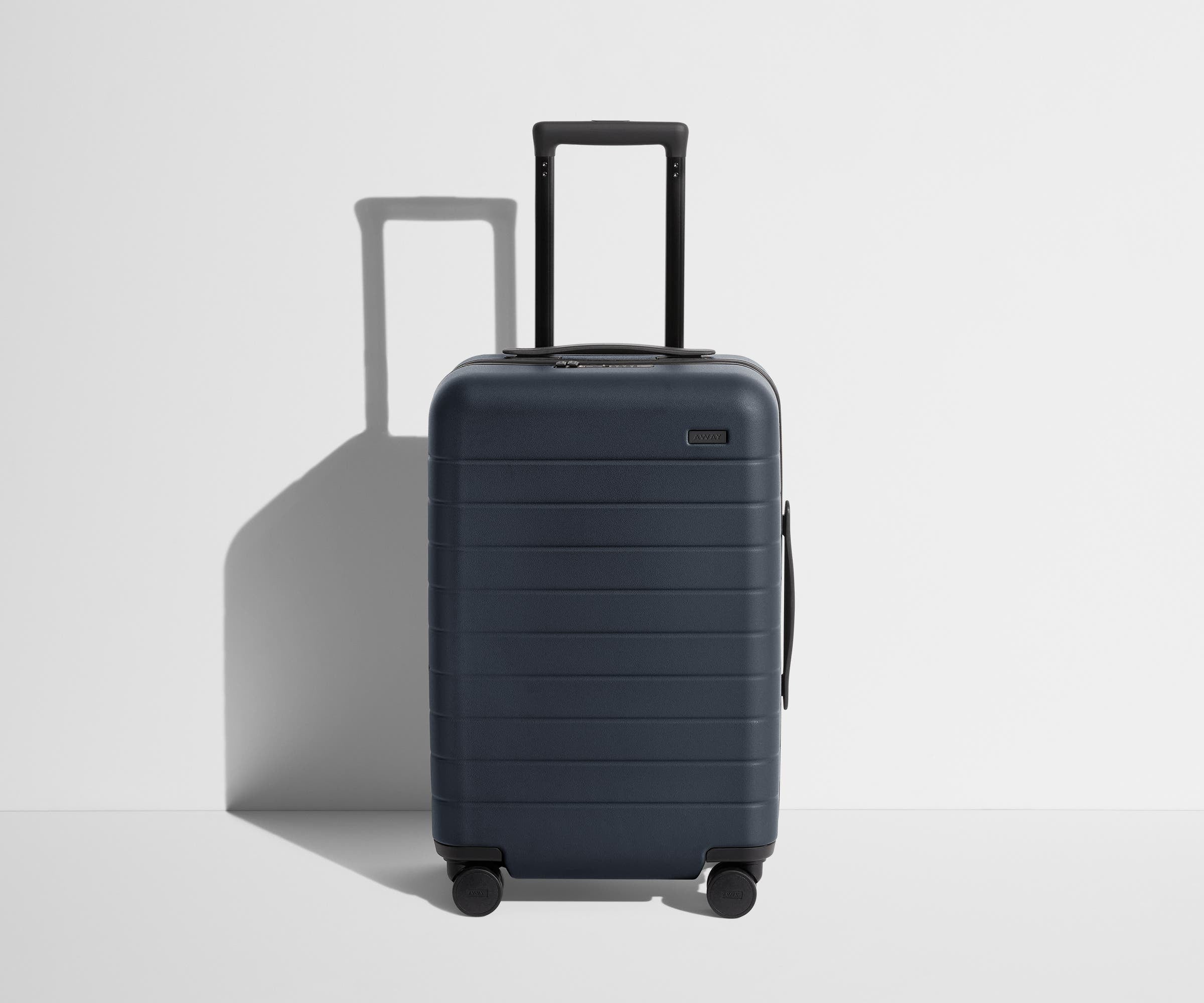 Front product view of The Carry-On suitcase in Navy Blue with raised handle