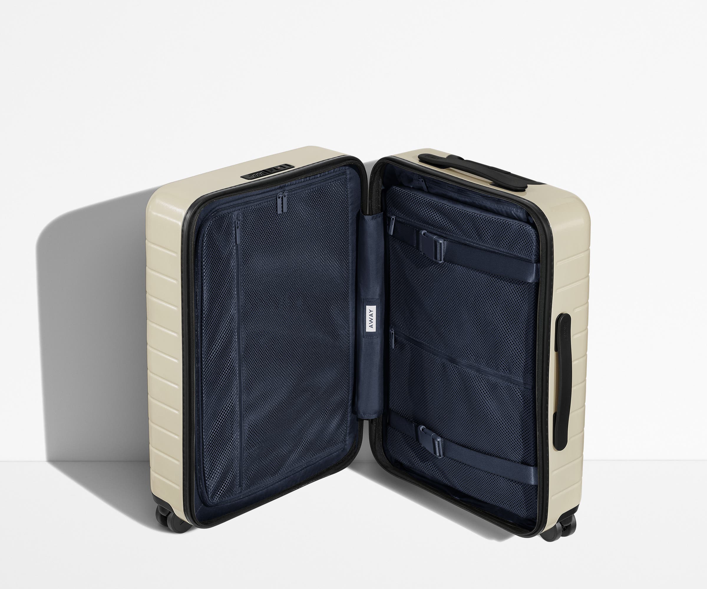 The Carry-On suitcase in Coast Blue shown open in an upright position to show interior organization and compression system