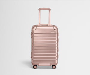 Front product view of a Rose Gold Aluminum Bigger Carry-On with handles raised