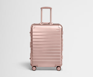 Front view of the Medium: Aluminum suitcase in Rose Gold with handles raised