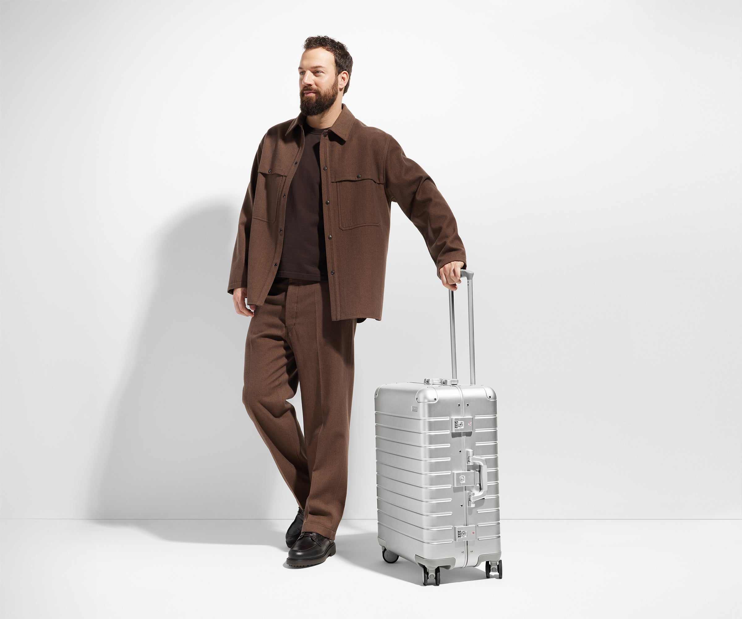 Person standing next to a Medium Aluminum suitcase