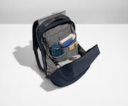 Everywhere Zip Backpack main compartment packed with a water bottle, books, clothing, and a key attached to the interior key leash. A laptop is packed in the exterior laptop pocket