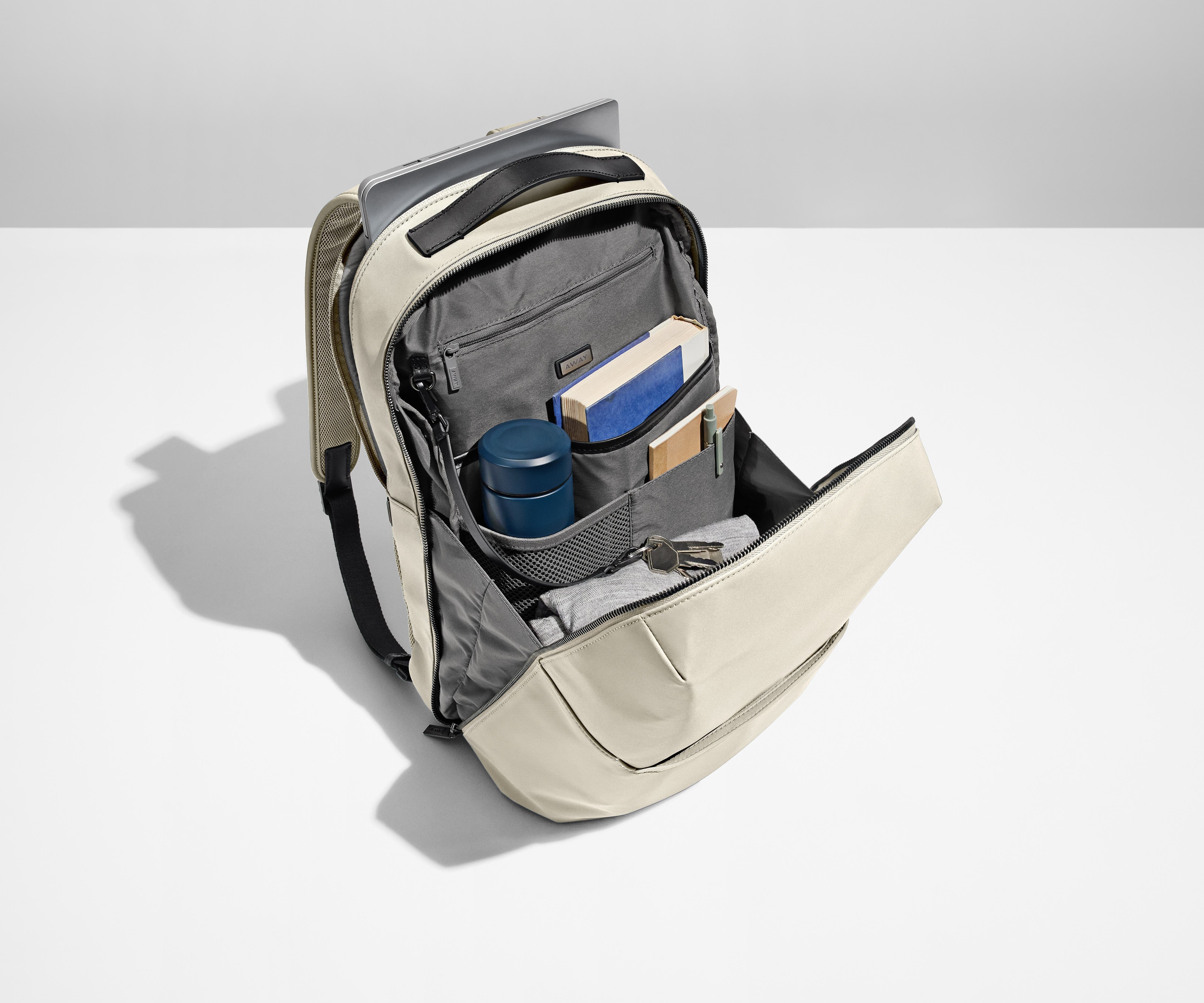 Main compartment packed with a water bottle, notebooks, and keys attached to the interior key leash. Laptop packed in the exterior laptop pocket