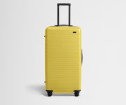 Front product view of The Trunk suitcase in Sunshine Yellow with raised handle