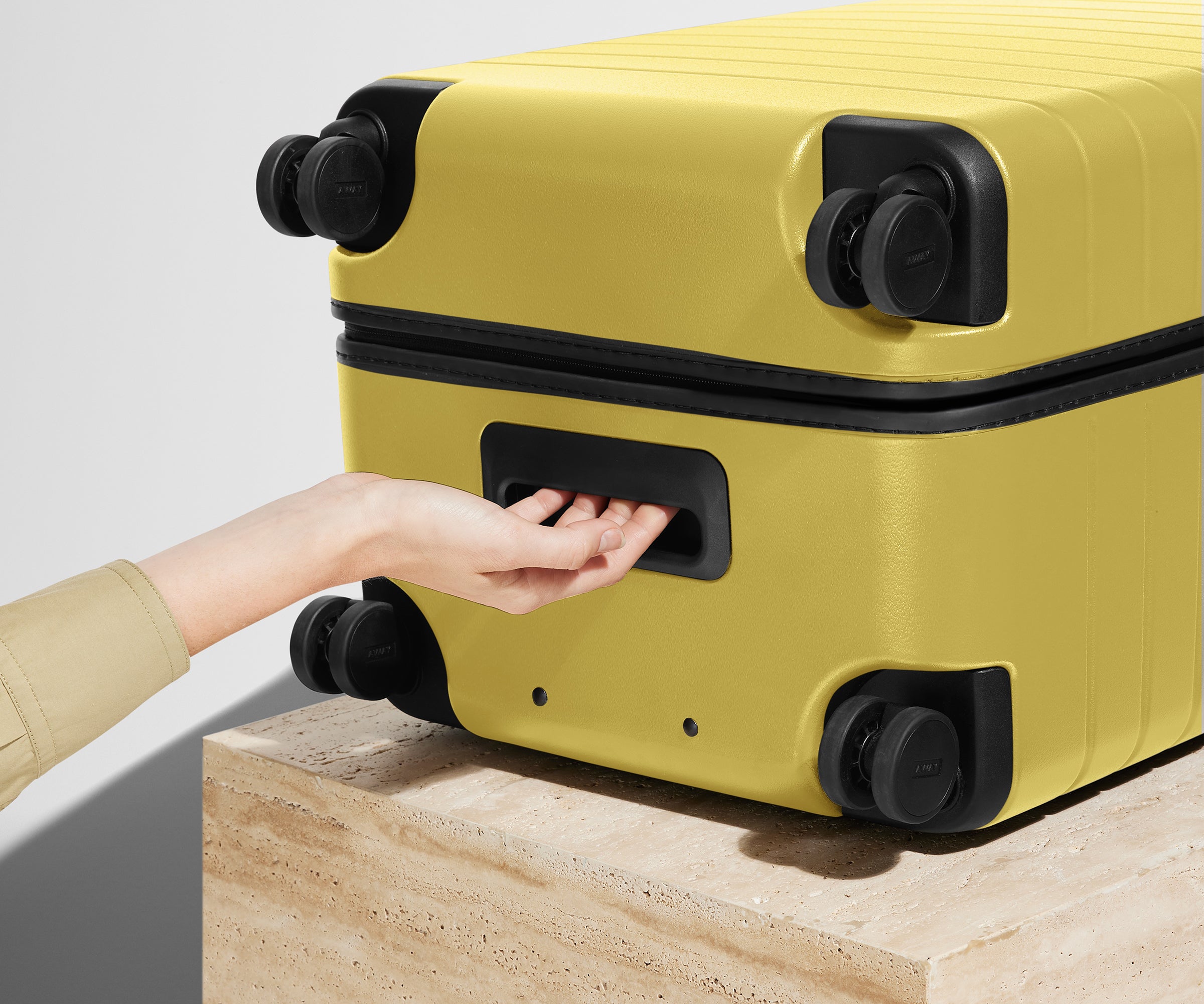 The Trunk suitcase in Sunshine Yellow shown from below highlighting the underside grab handle