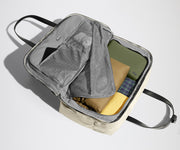 Open clamshell Weekender bag packed with travel essentials, including clothes and Small Toiletry Bag