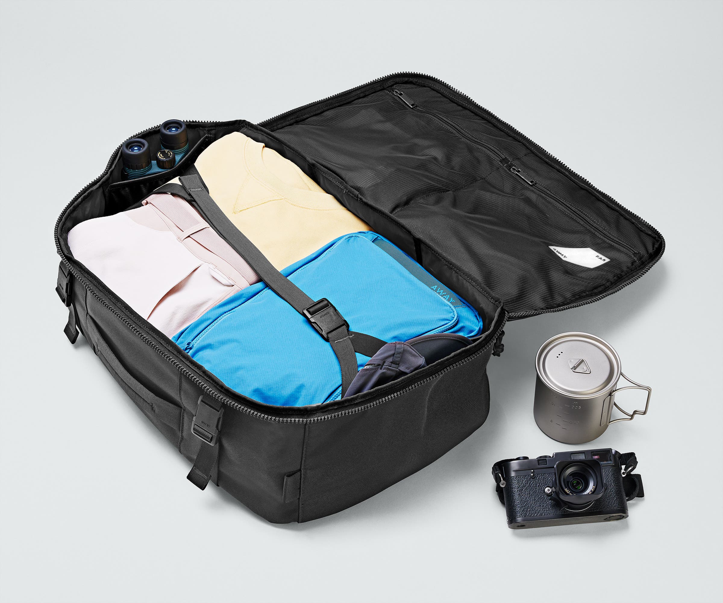 Active Convertible Backpack 45L packed with clothing, a camera, travel mug, and binoculars