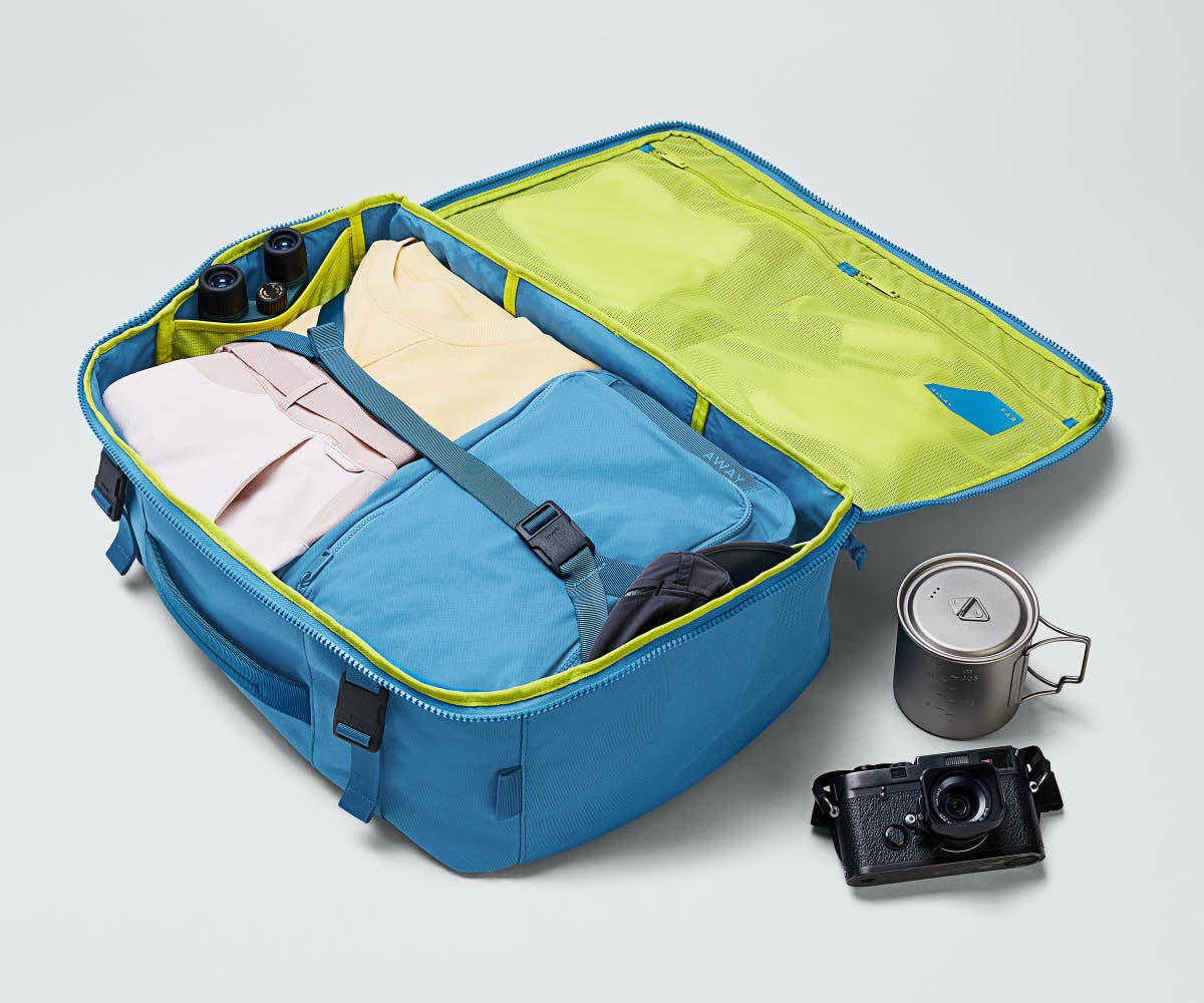 Active Convertible Backpack 45L packed with clothing, a camera, travel mug, and binoculars