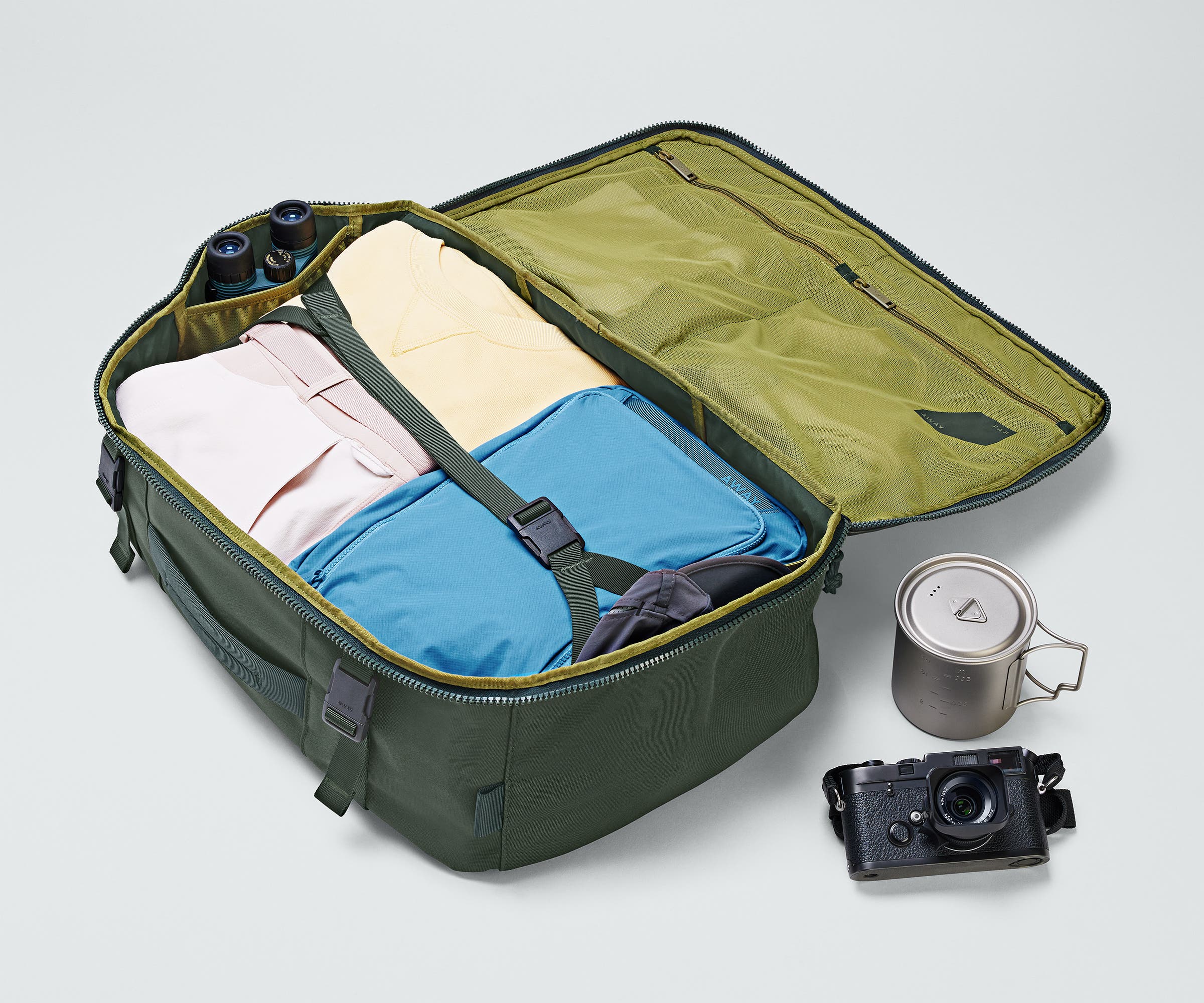 Active Convertible Backpack 45L packed with clothing, a camera, travel mug, and binoculars