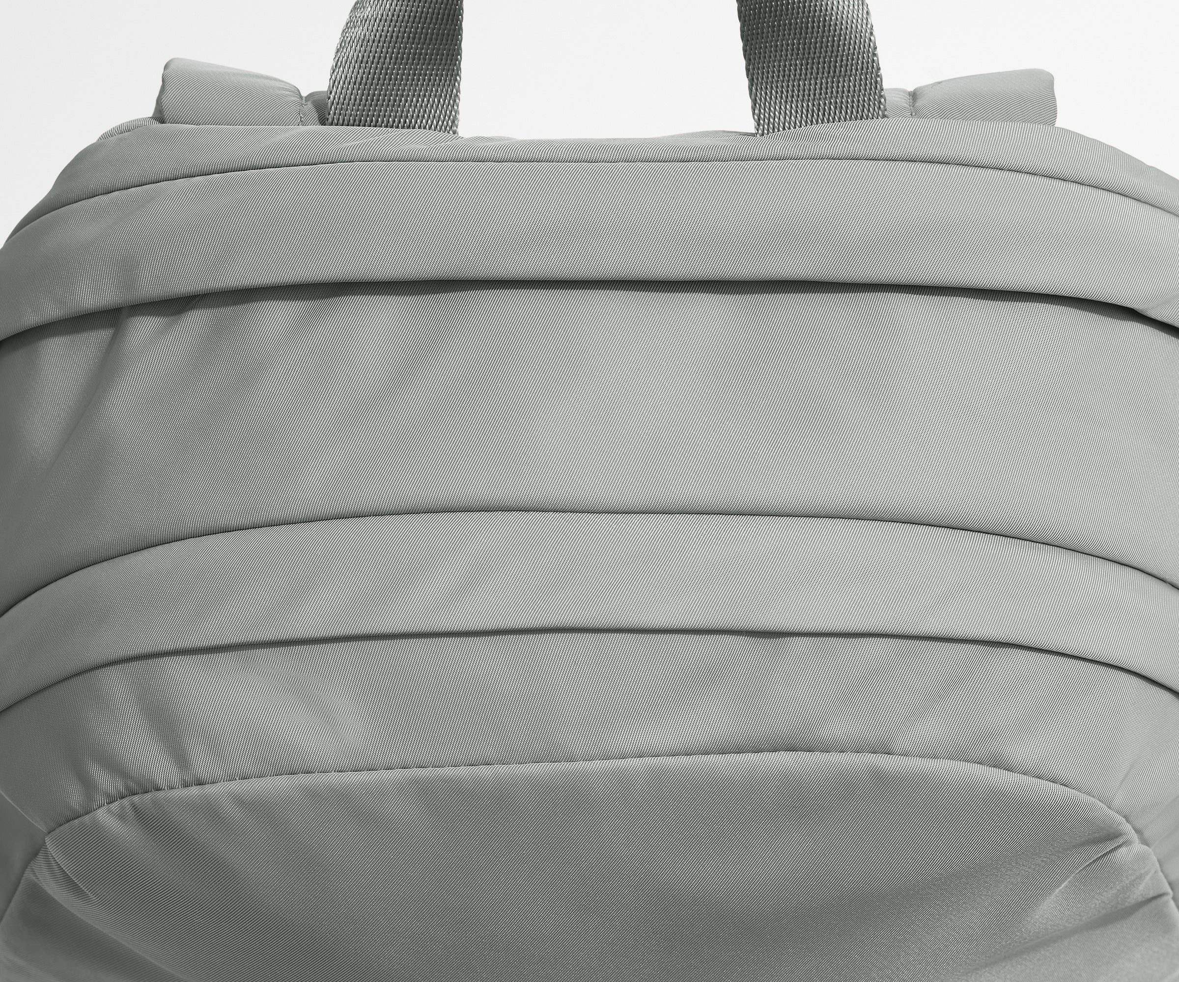 Close-up of a gray backpack with visible stitching details.