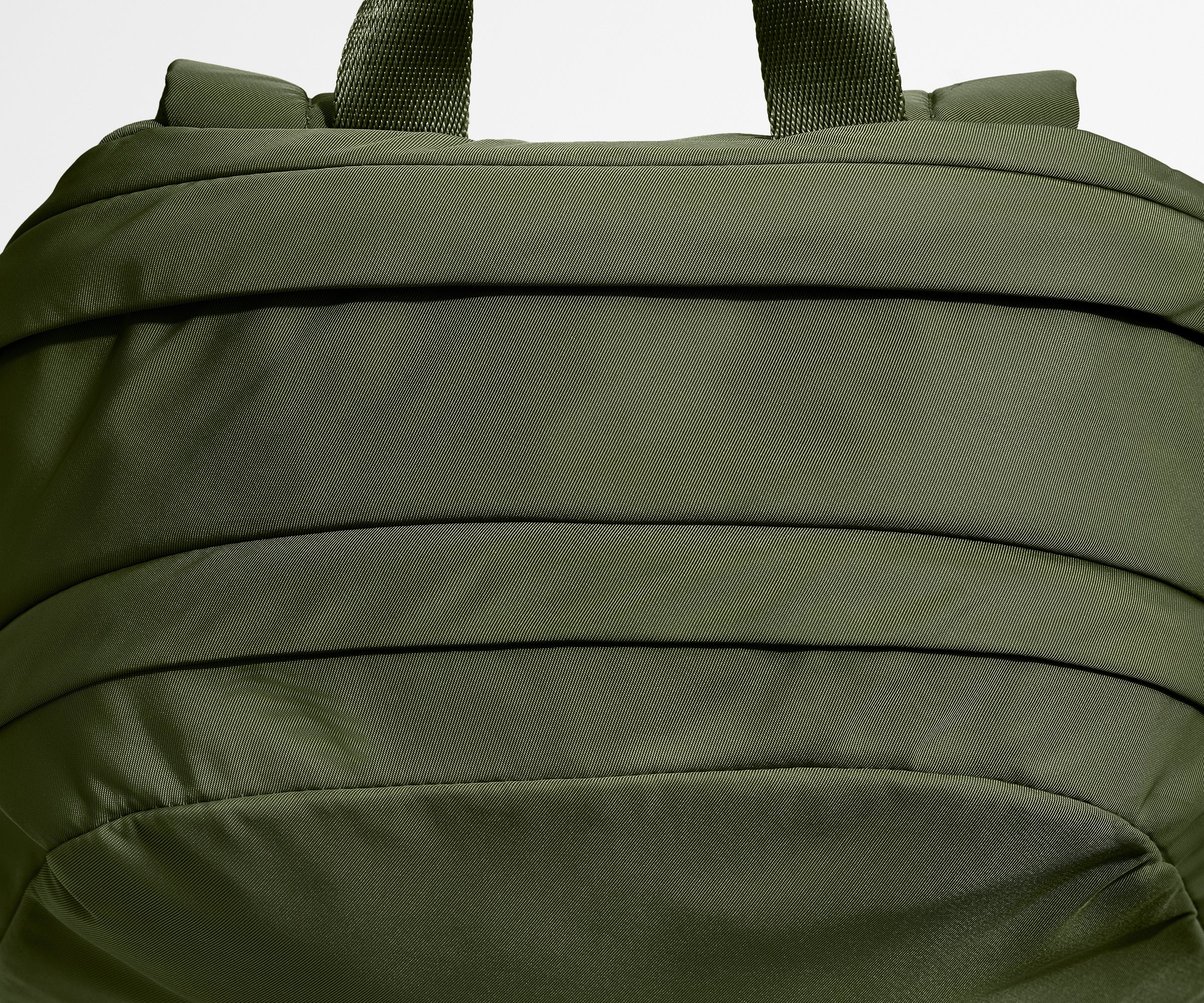 Close-up of a green backpack with straps on a white background
