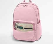 Pink backpack with a pocket open on a white background