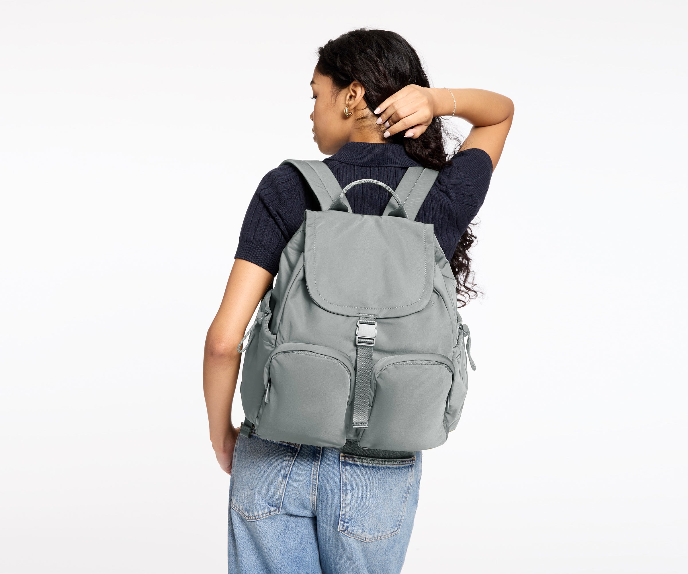 Person wearing a gray backpack on a white background