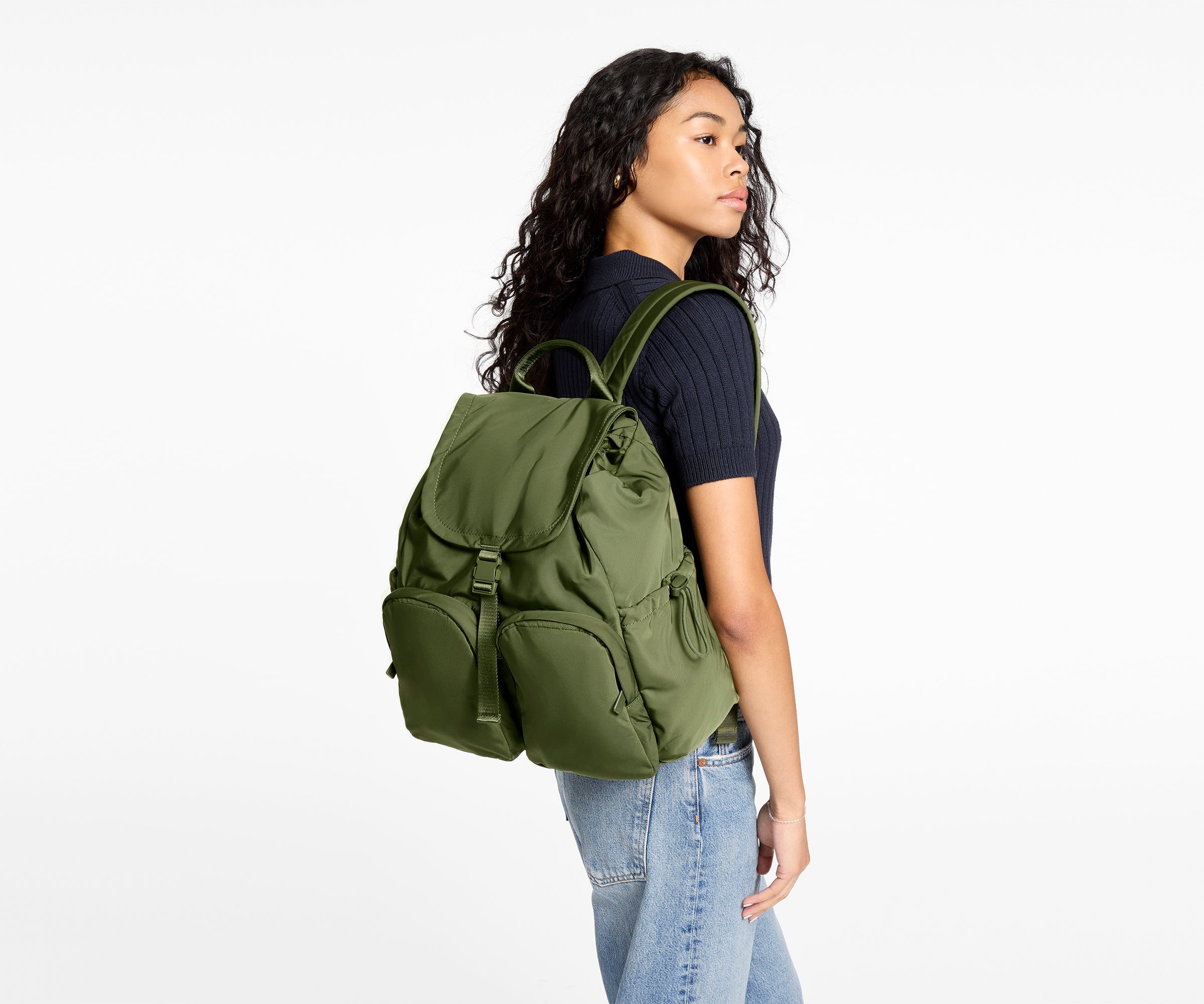 Person wearing a green backpack on a white background