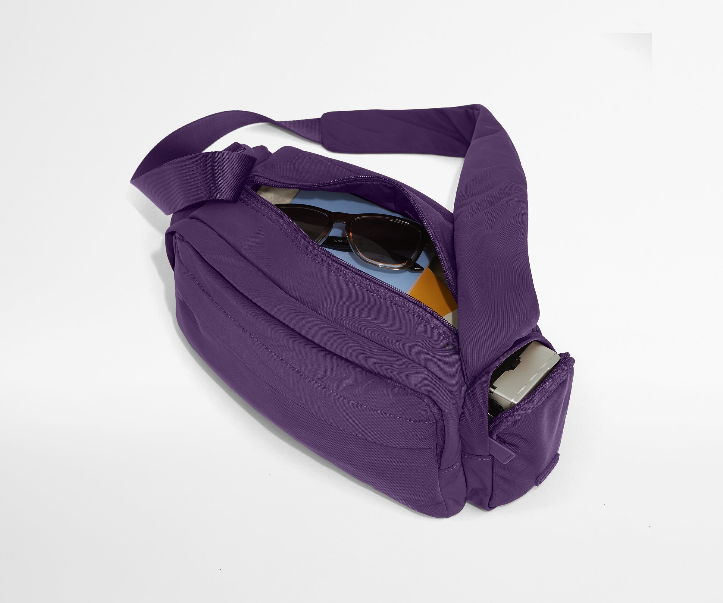 Featherlight Cargo Pack packed with notebooks, sunglasses, and a camera