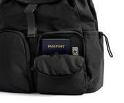 Black backpack with a passport in a pocket on a white background