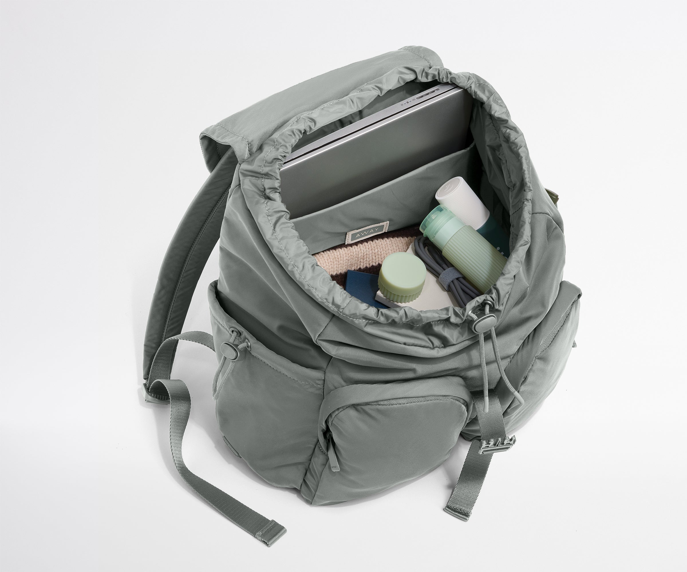 Gray backpack with items inside on a white background
