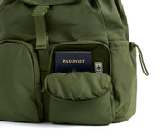 Green backpack with a passport in an open pocket on a white background