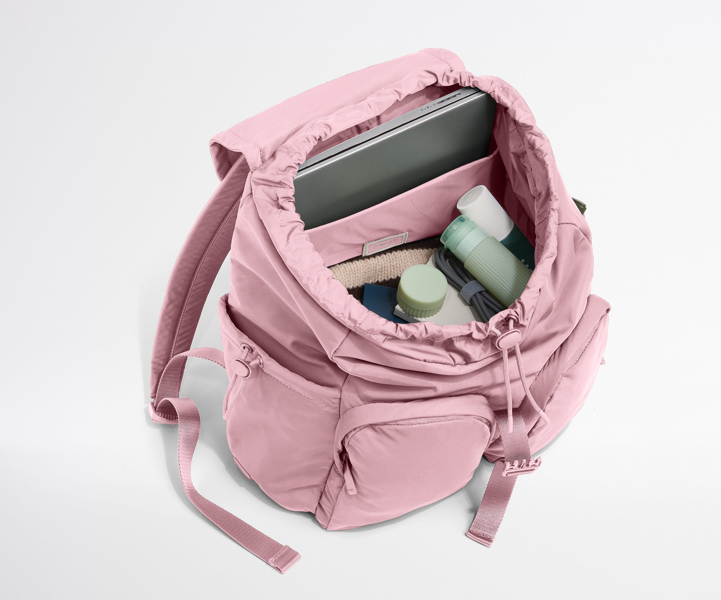 Pink backpack with items inside on a white background