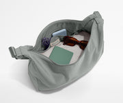 Gray waist bag with sunglasses and phone on a white background