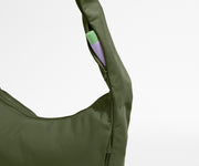 Green bag with a small purple pouch inside on a light gray background