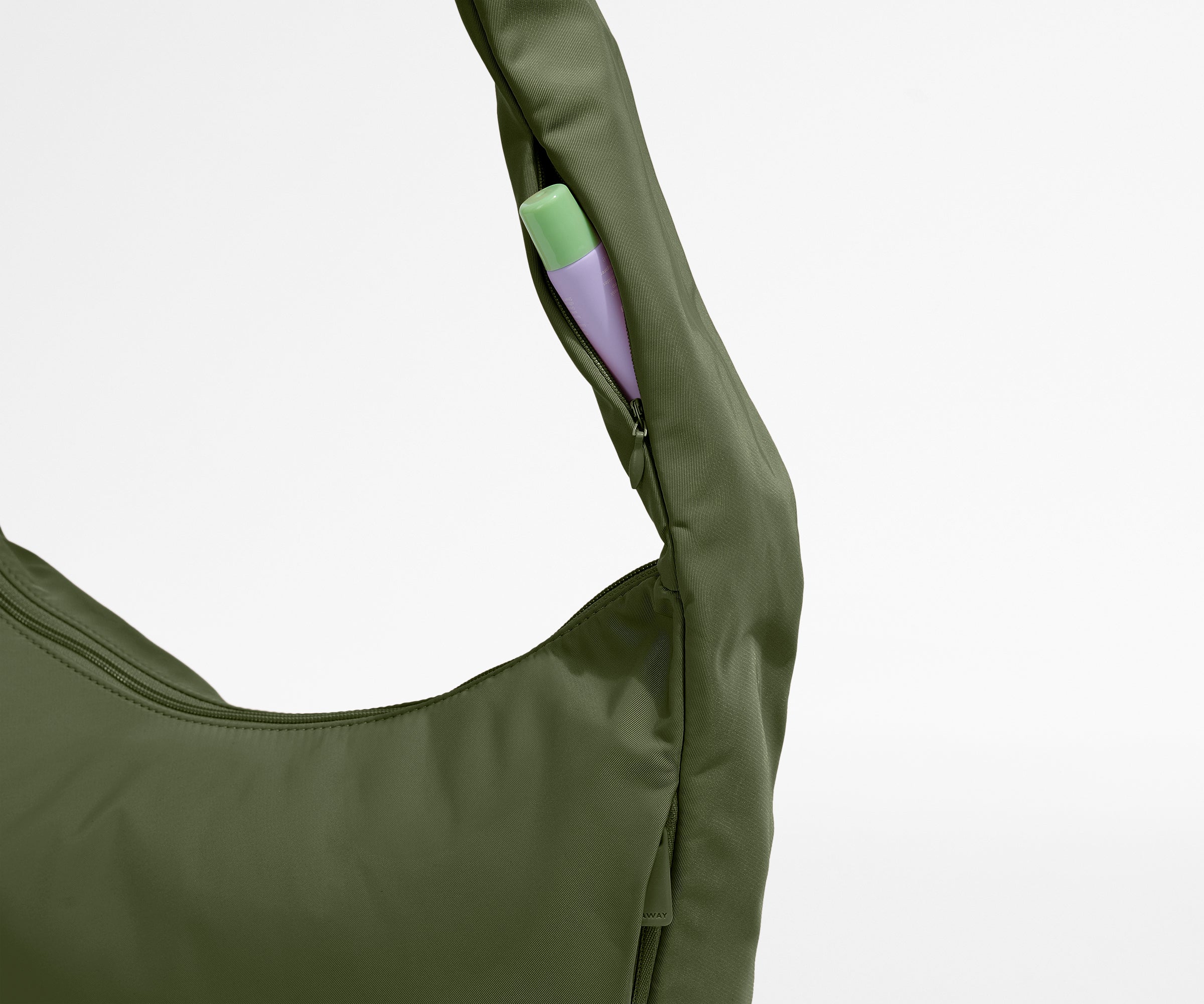 Green bag with a small purple pouch inside on a light gray background