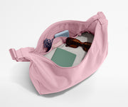 Pink baby carrier with items inside on a white background