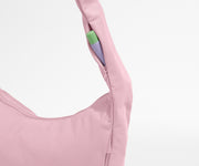 Close-up of a pink garment with a green and purple tag on a white background