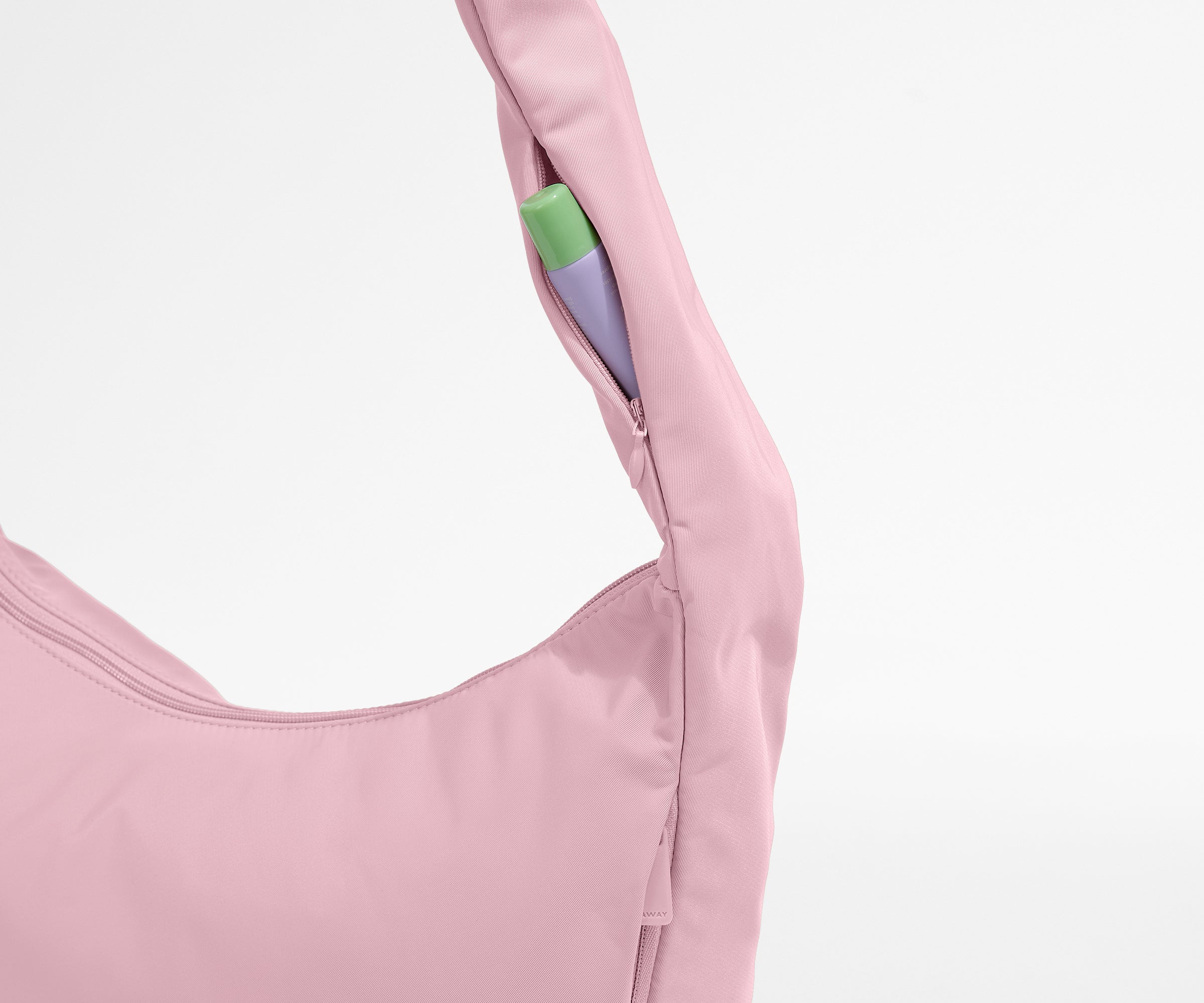 Close-up of a pink garment with a green and purple tag on a white background