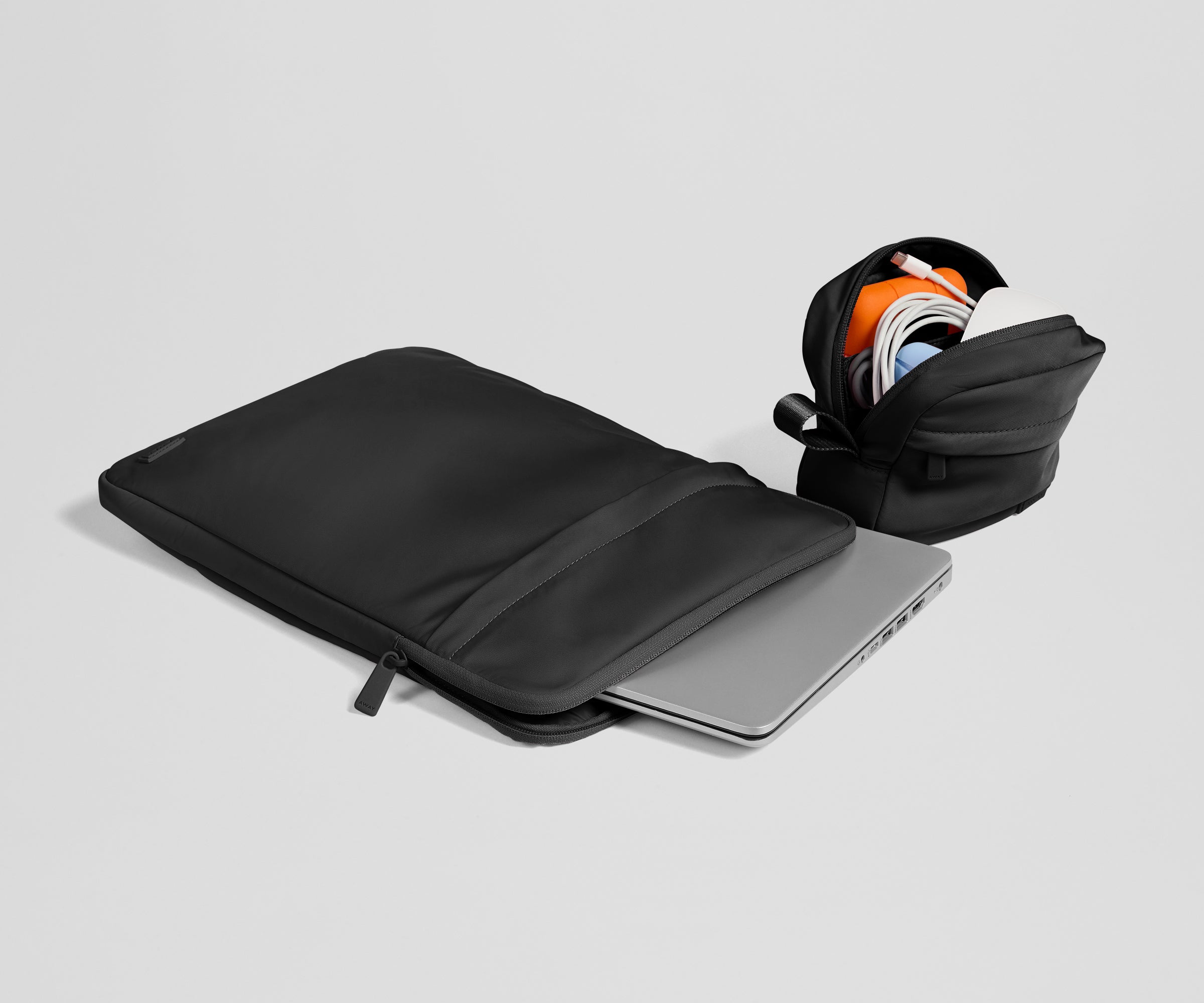 Black laptop sleeve with a silver laptop inside on a light gray background