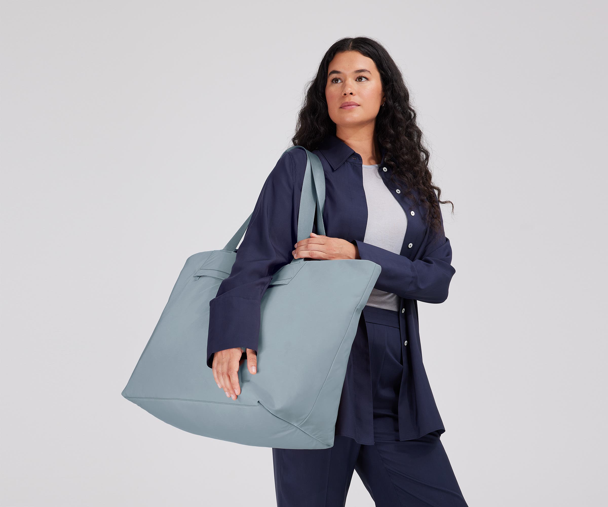 Person wearing the Large Featherlight Tote on their shoulder using the longer shoulder straps