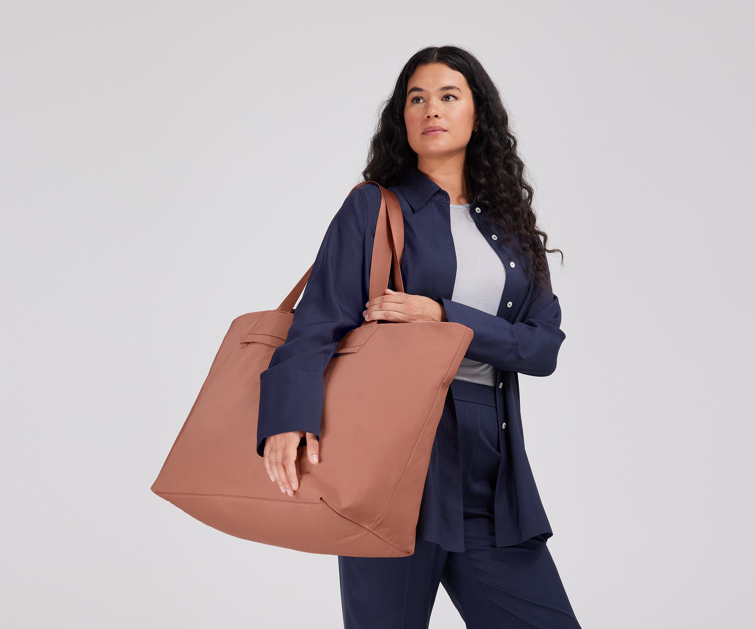 Person wearing the Large Featherlight Tote on their shoulder using the longer shoulder straps