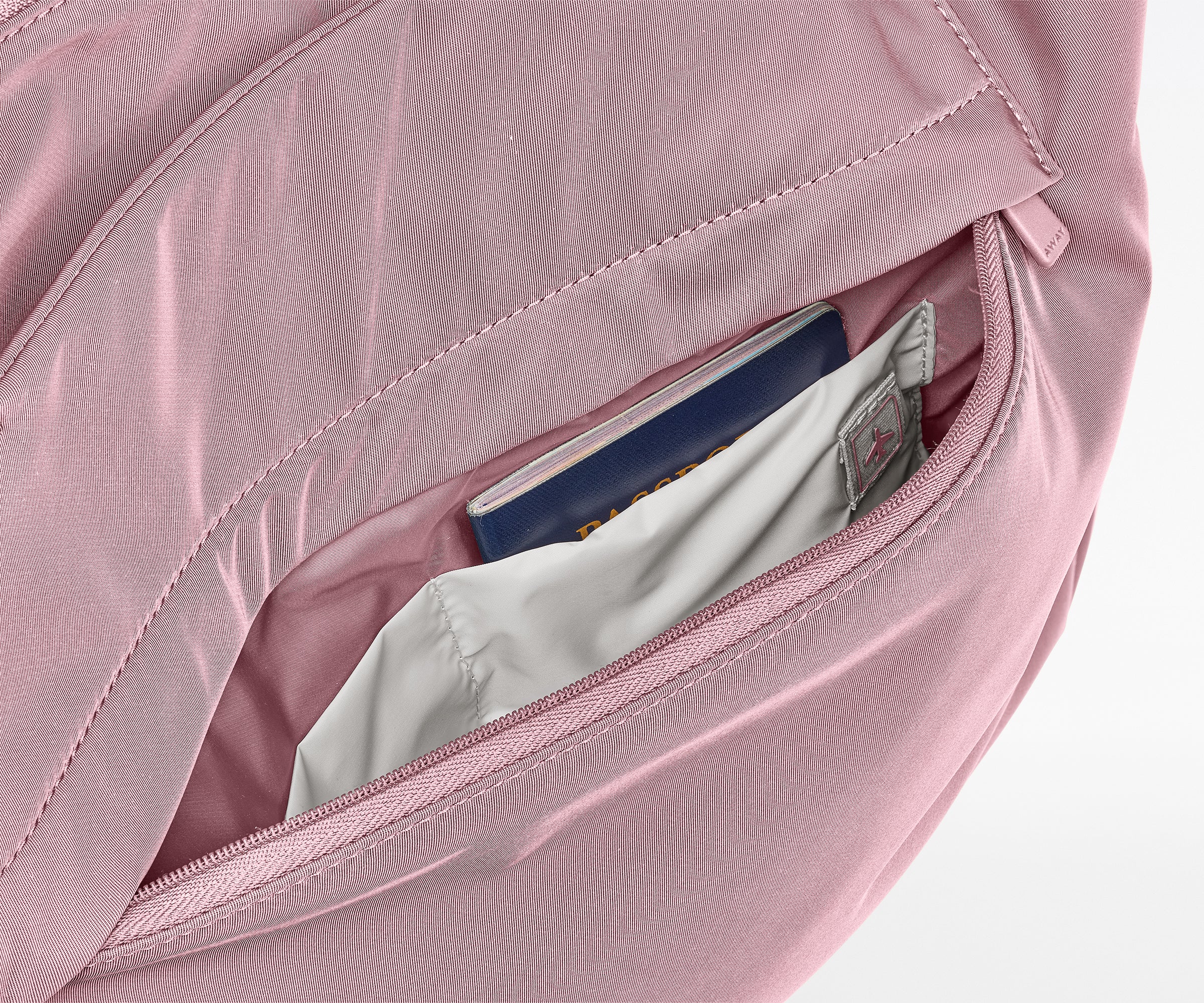 Pink bag with a compartment open, revealing a passport and money.
