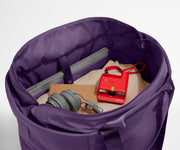 Interior packed with clothing, a laptop, headphones, notebook, and camera