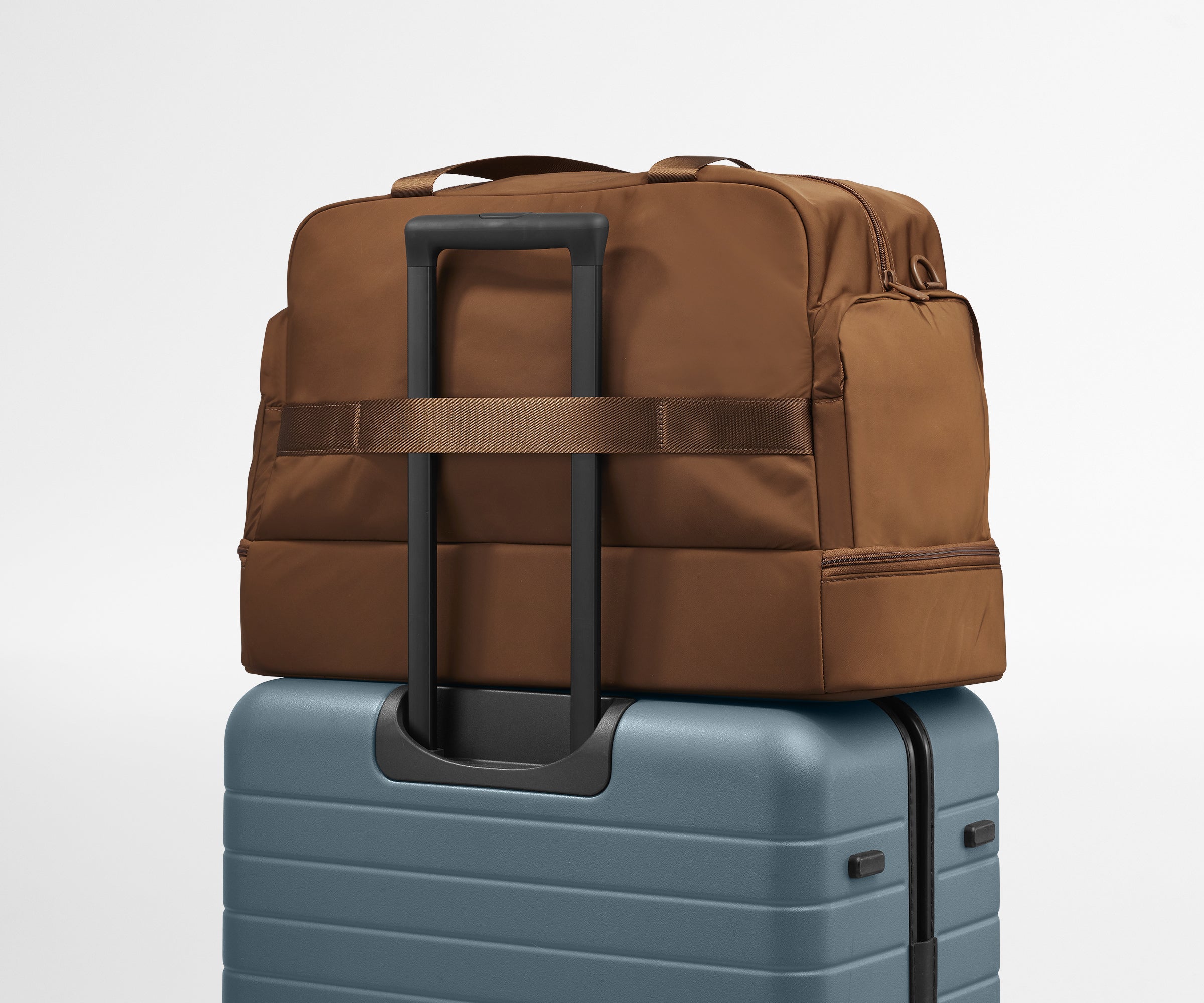 Featherlight Weekender shown on top of an Away suitcase