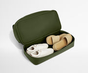 Green travel shoe case with white and beige shoes on a light gray background