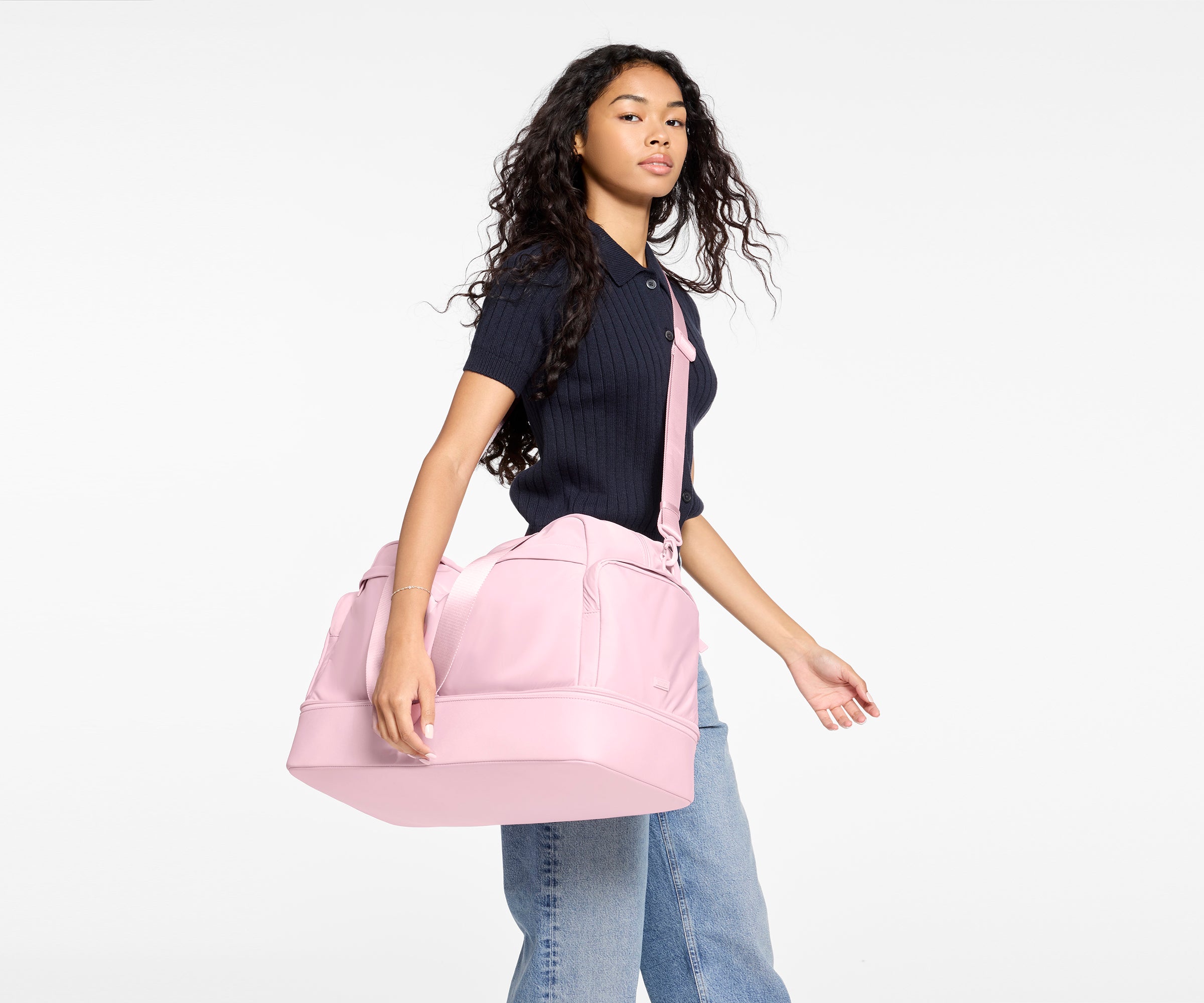 Person holding a pink bag against a white background