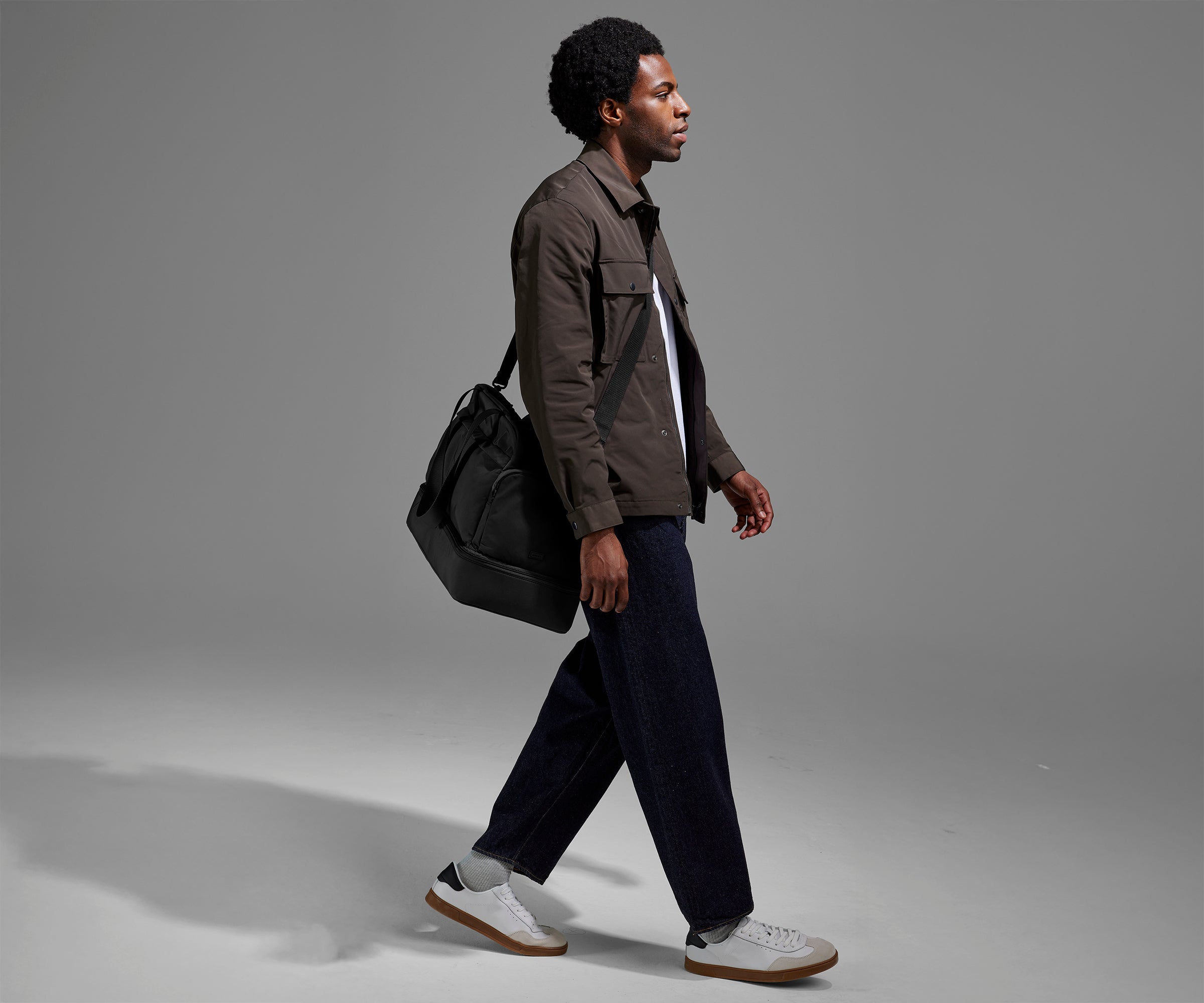 Person wearing the Featherlight Weekender as a crossbody with the detachable strap