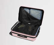 The Bigger Carry-On Flex suitcase in Blush Pink shown open on its side and packed with Away's packing organizers to show capacity and the interior compression system, designed to help you pack more in