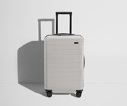Front product view of The Bigger Carry-On Flex suitcase in Cloud Gray with raised handle