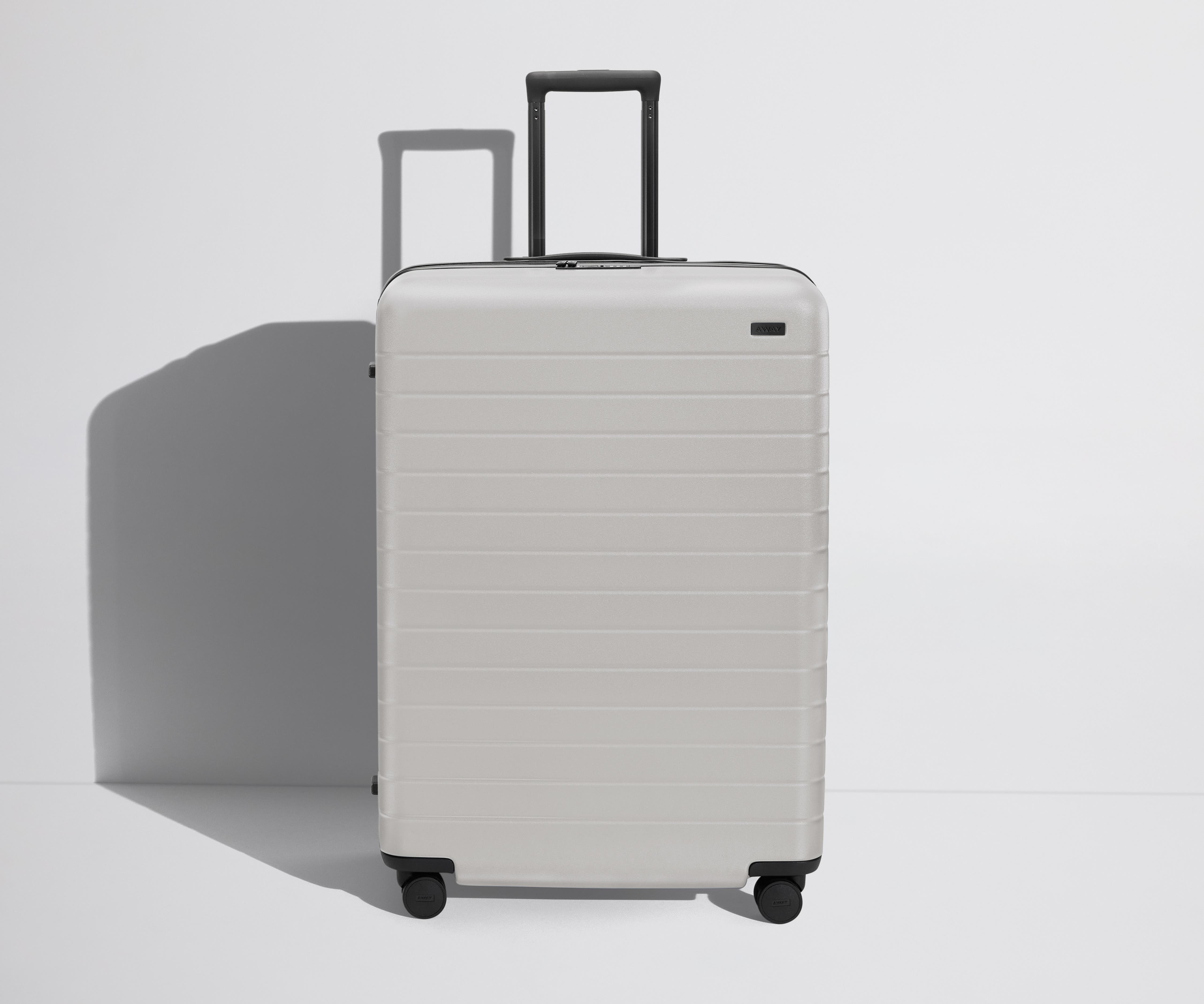 Front product view of The Large Flex suitcase in Cloud Gray with raised handle