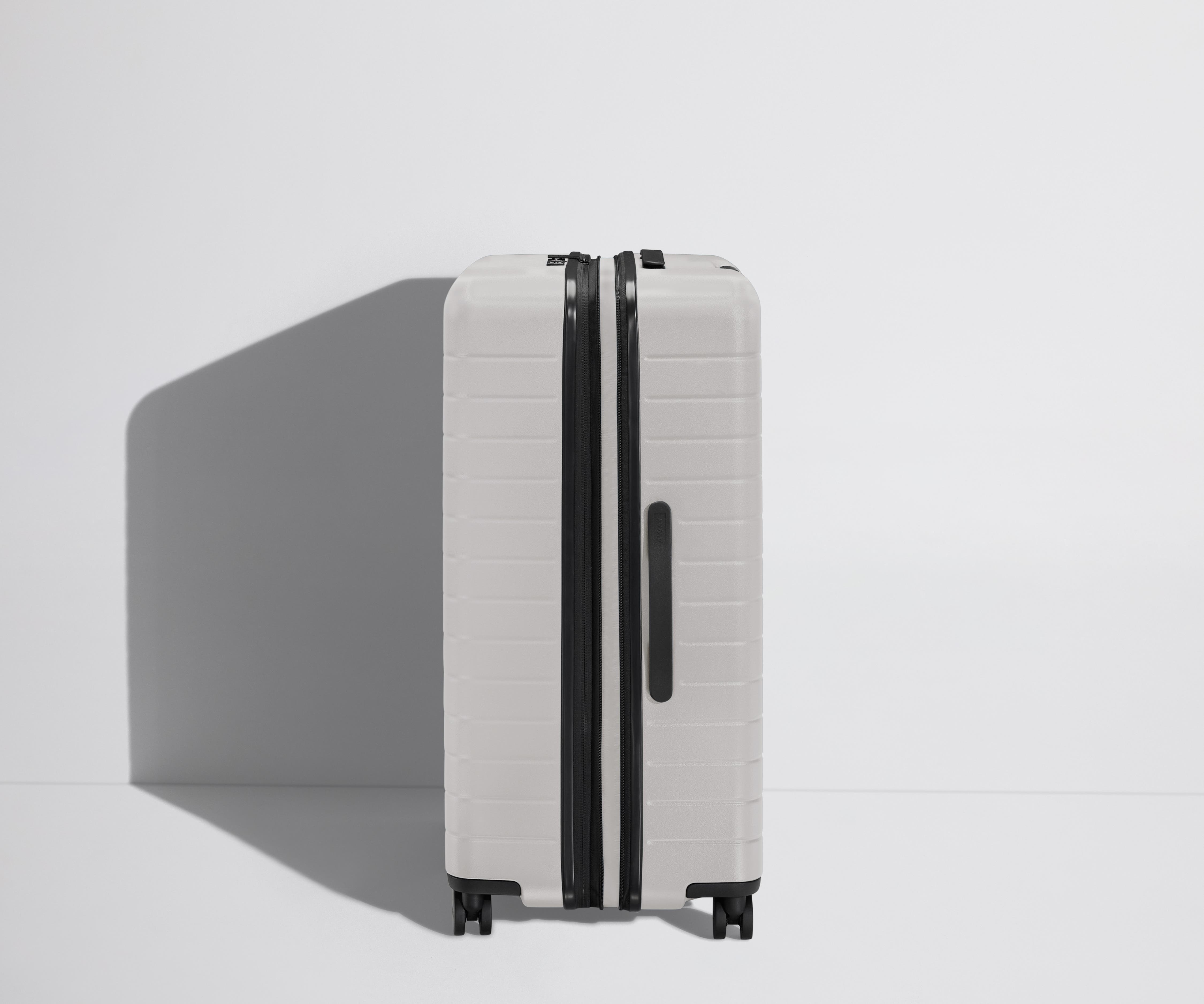 Side product view of The Large Flex suitcase in Cloud Gray shown fully expanded