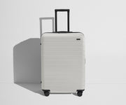 Front product view of The Medium Flex suitcase in Cloud Gray with raised handle