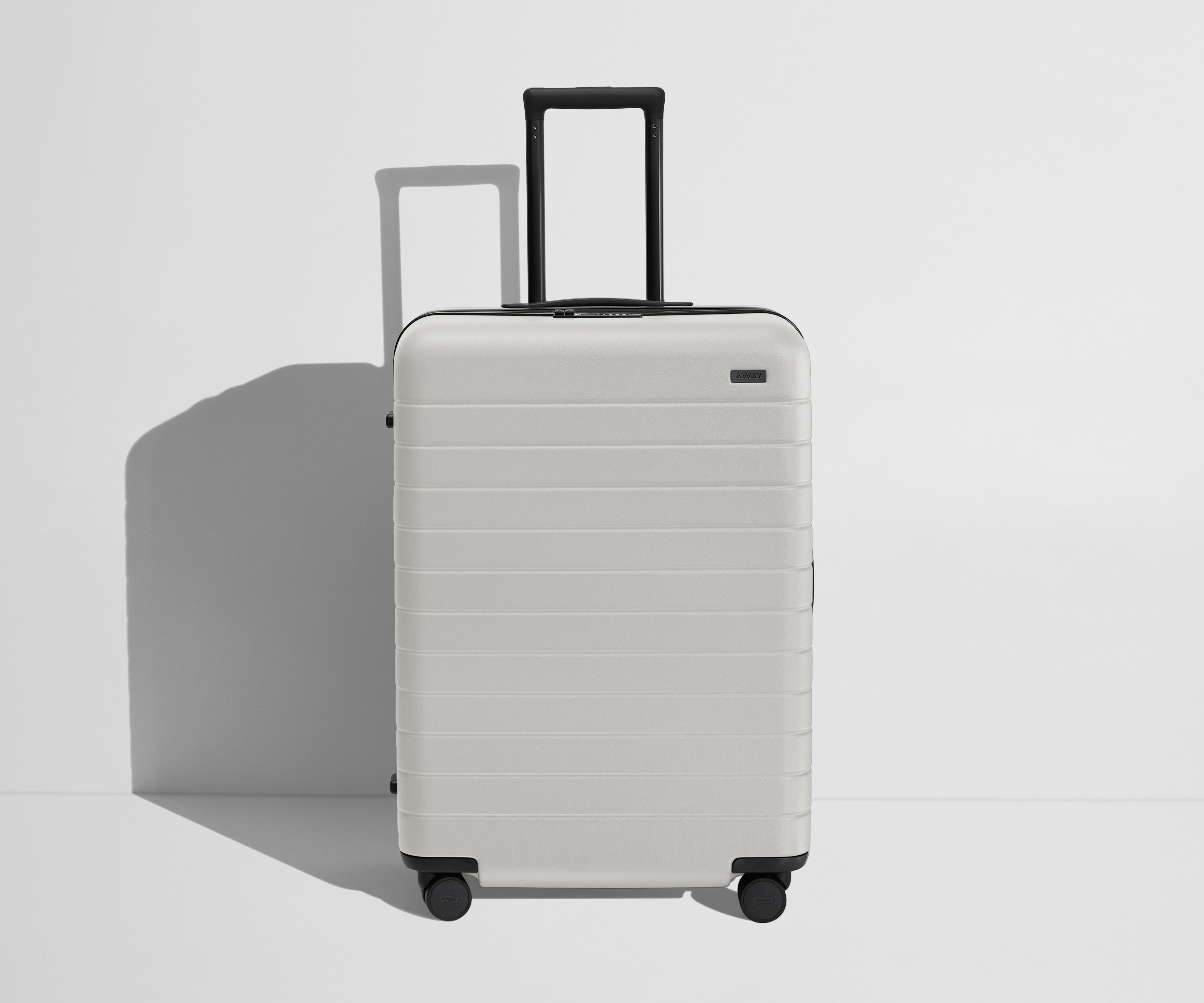 Front product view of The Medium Flex suitcase in Cloud Gray with raised handle