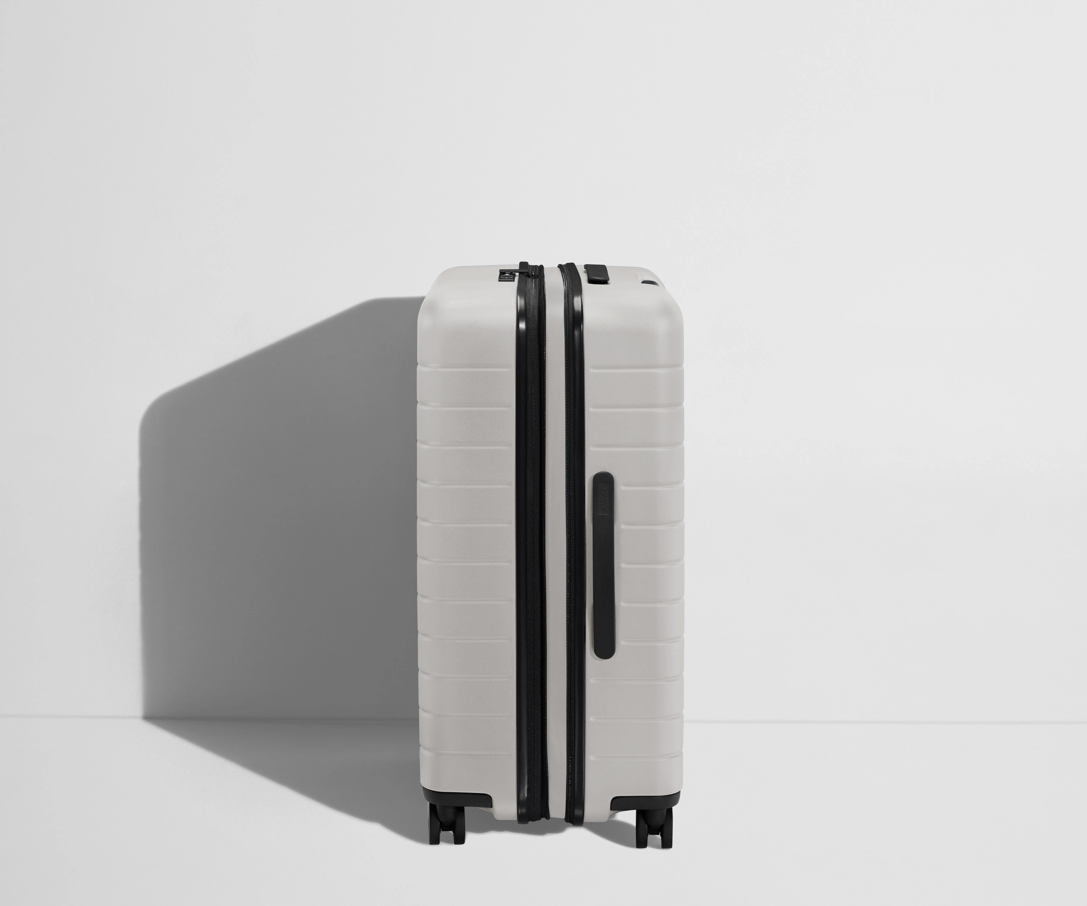 Side product view of The Medium Flex suitcase in Cloud Gray shown fully expanded