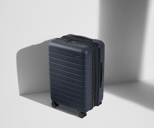 Angled product view of The Bigger Carry-On Flex suitcase in Navy Blue