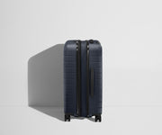 Side product view of The Bigger Carry-On Flex suitcase in Navy Blue shown fully expanded