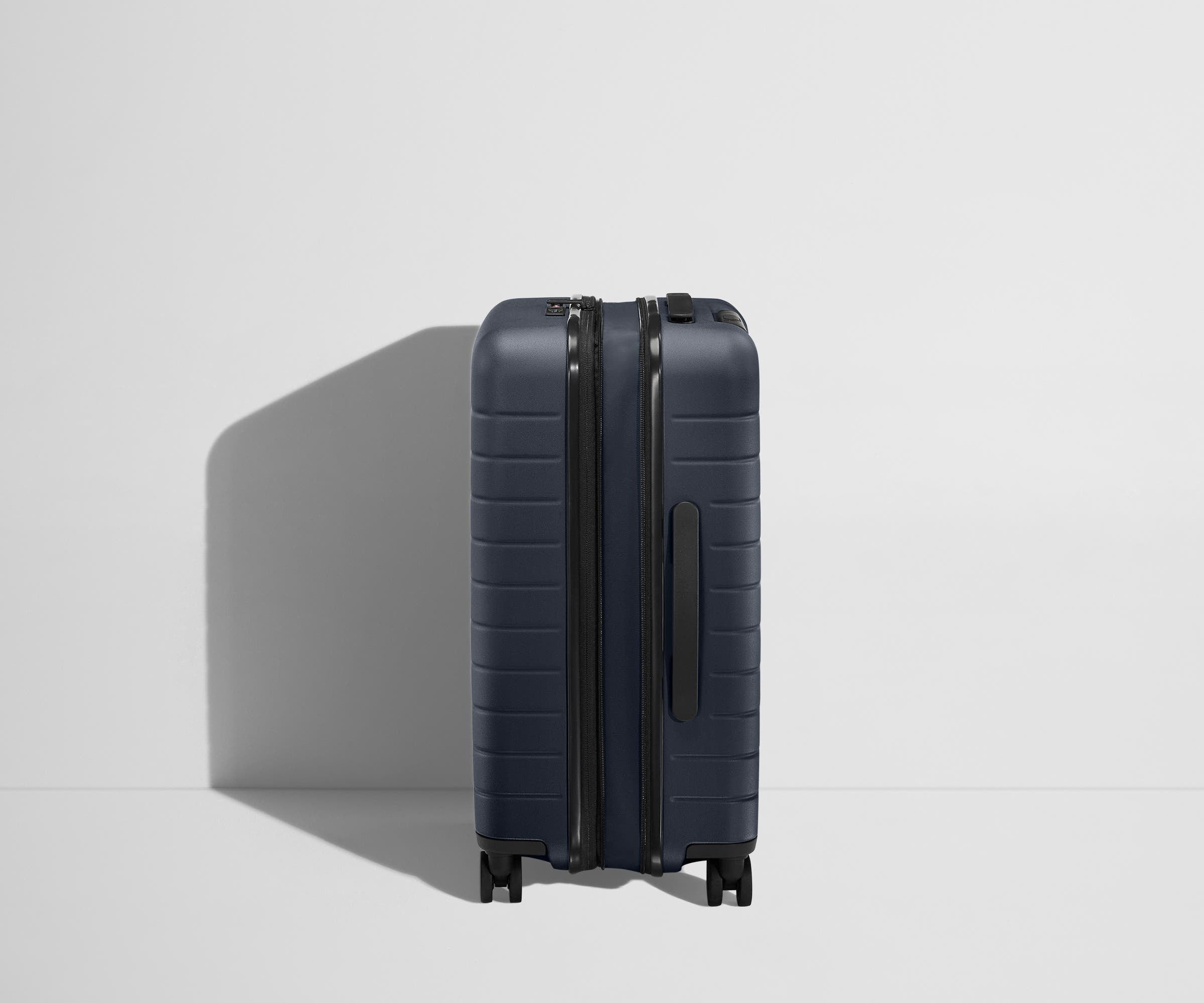 Side product view of The Bigger Carry-On Flex suitcase in Navy Blue shown fully expanded